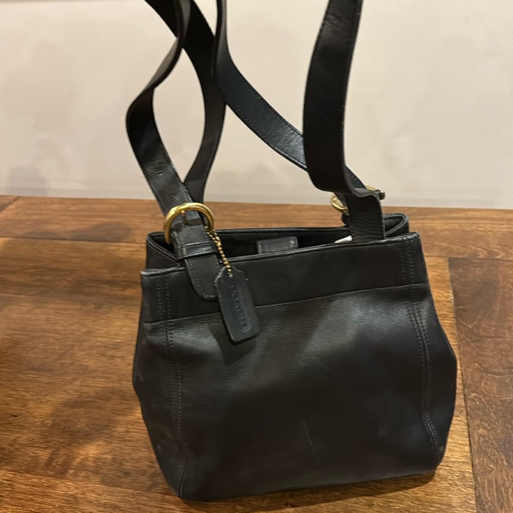 Vintage black coach shoulder bag with brass buckle adjustable straps.